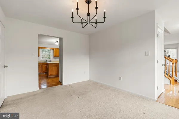 a view of a hallway with wooden floor and a chandelier