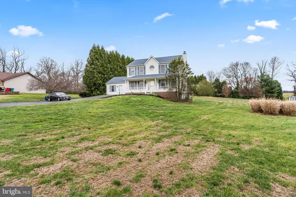 a view of a house with a big yard and large trees
