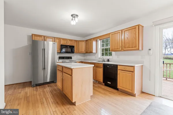 a kitchen with stainless steel appliances granite countertop a refrigerator stove top oven and sink