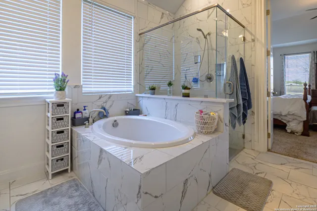 a spacious bathroom with a bathtub sink and mirror