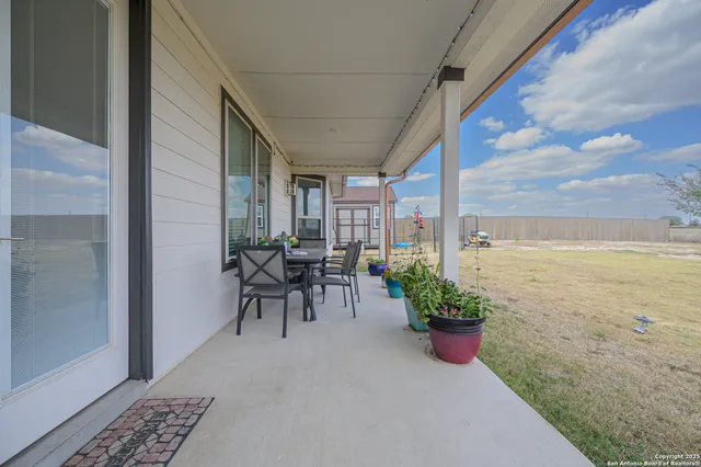 a view of a patio with table and chairs and potted plants