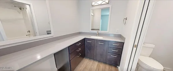 a bathroom with a granite countertop sink toilet and shower