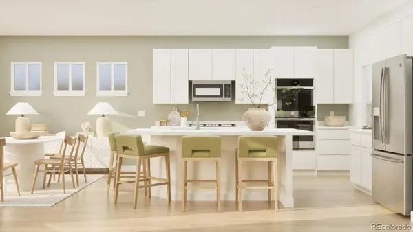 a kitchen with stainless steel appliances kitchen island granite countertop a table chairs and a refrigerator