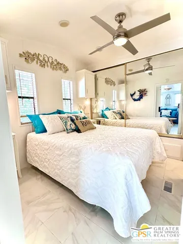 a bedroom with a bed window and a ceiling fan