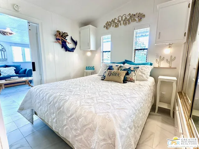 a bedroom with a bed and a large mirror