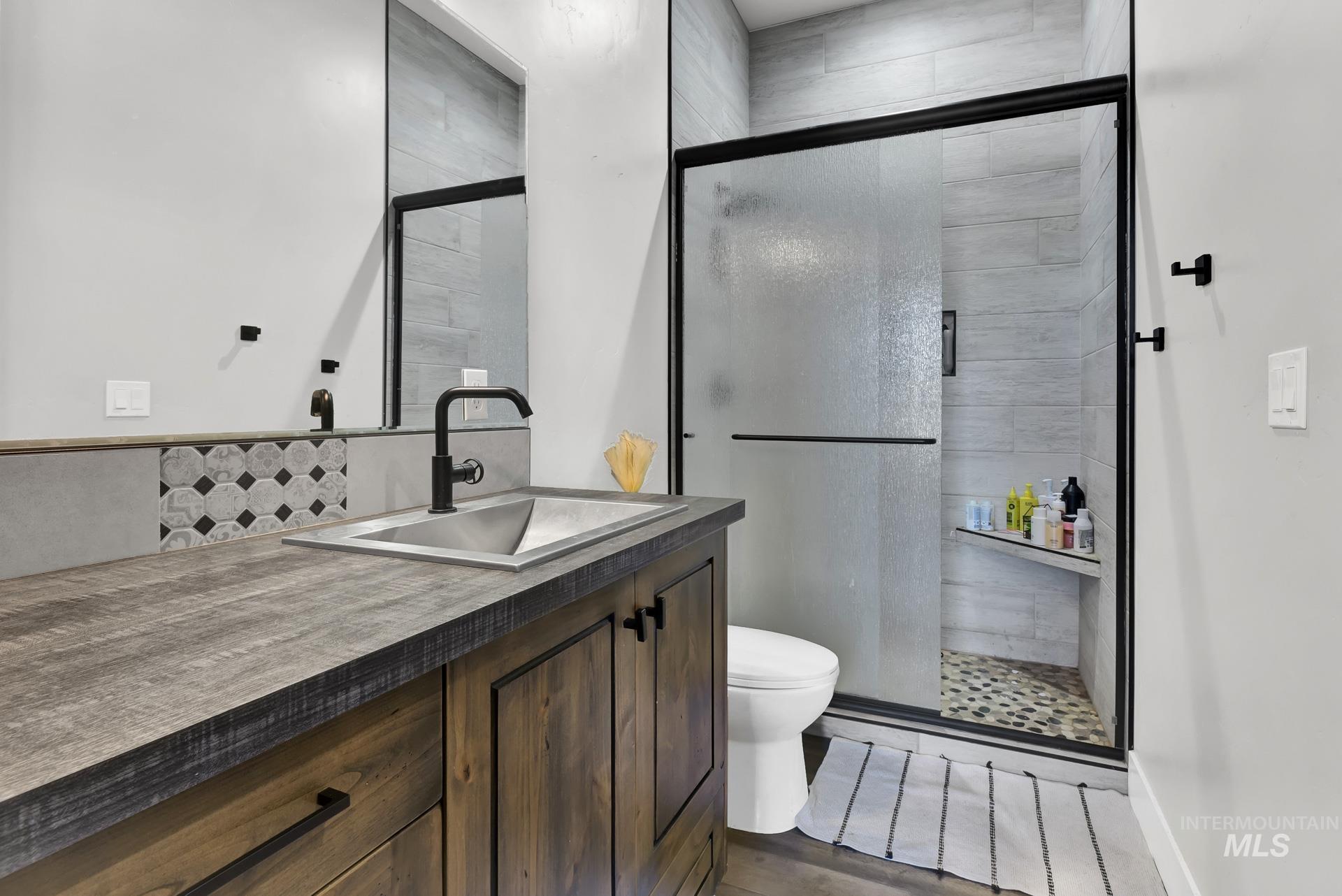 27114 Lower Pleasant Ridge Road Wilder, ID 83676 - Photo 22 of 48 Full bathroom with vanity, a shower stall, and wood finished floors