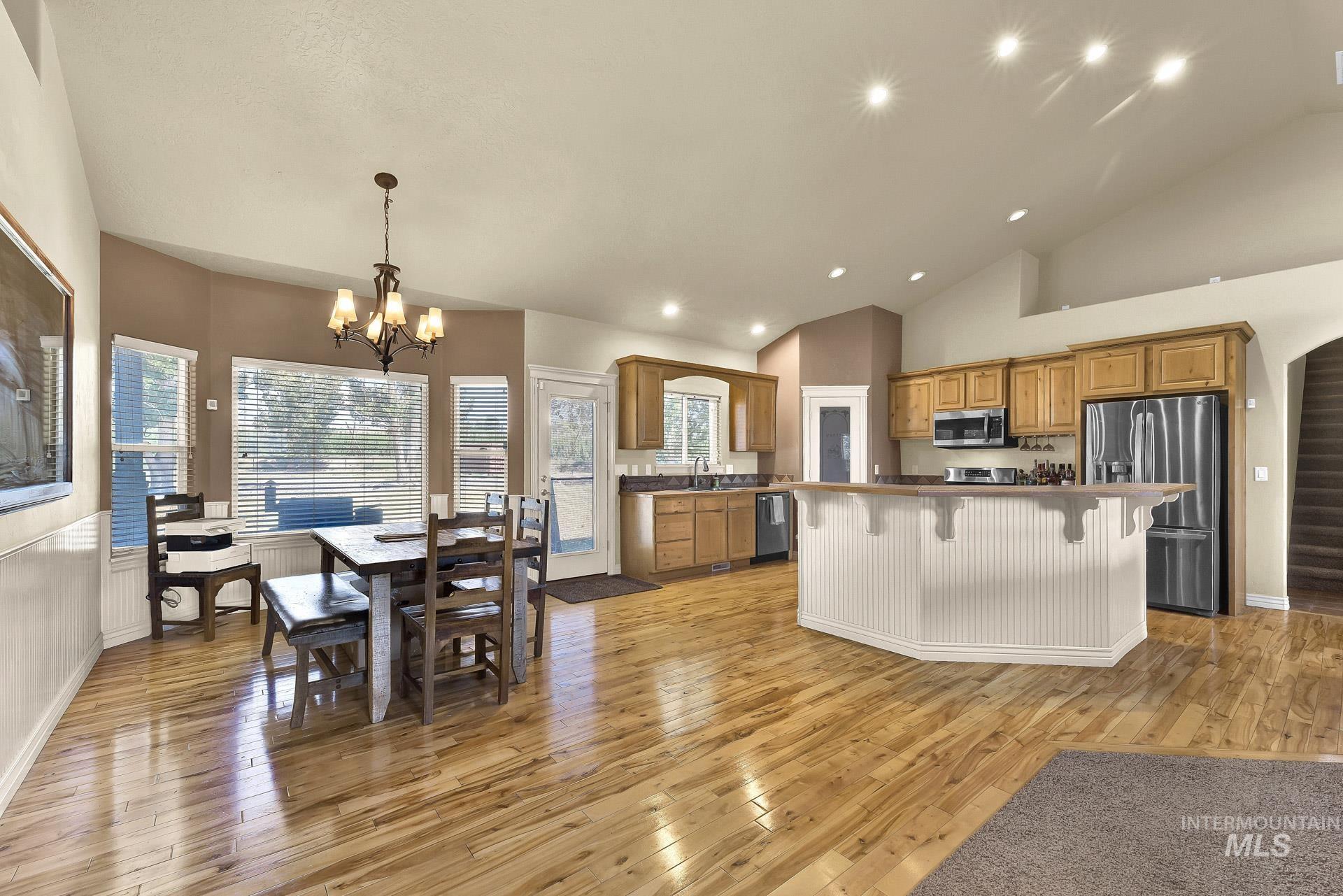 27114 Lower Pleasant Ridge Road Wilder, ID 83676 - Photo 35 of 50 Kitchen with stainless steel appliances, light wood-style flooring, a kitchen breakfast bar, brown cabinets, and a kitchen island