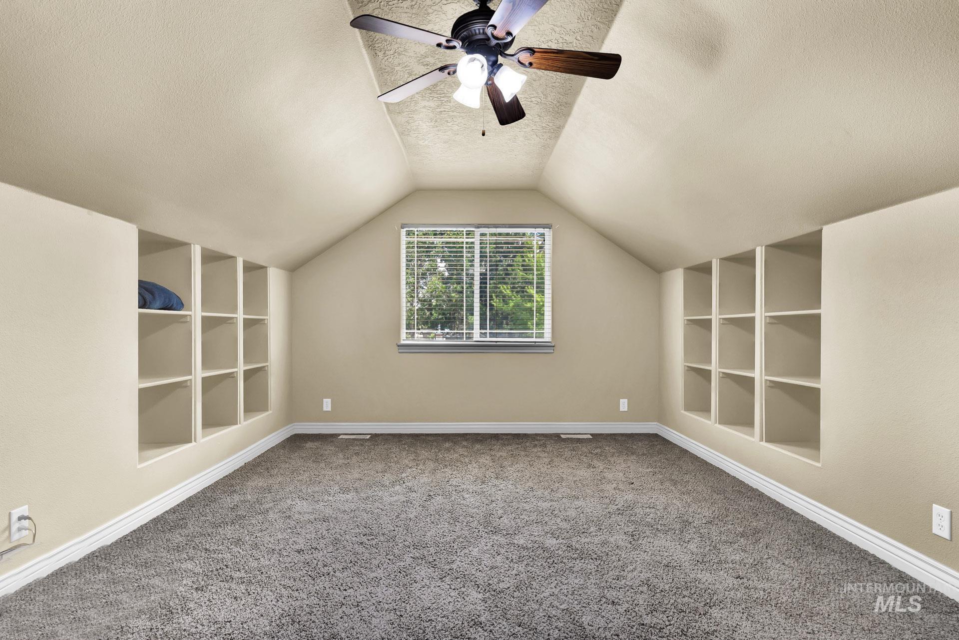 27114 Lower Pleasant Ridge Road Wilder, ID 83676 - Photo 43 of 48 Bonus room featuring built in features, a textured ceiling, lofted ceiling, carpet, and a ceiling fan