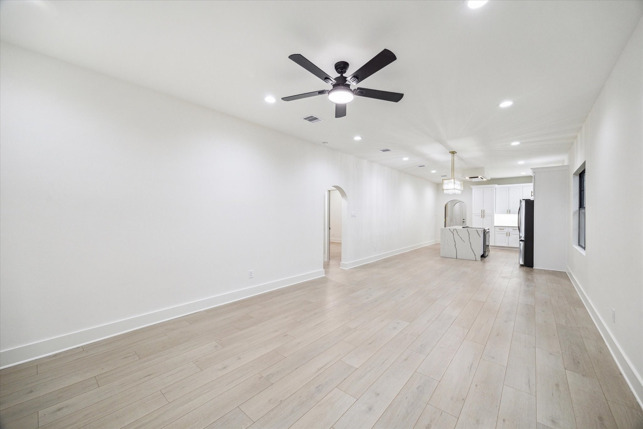 228 Lenox Street Houston, TX 77011 - Photo 3 of 16 a view of an empty room with a ceiling fan and wooden floor