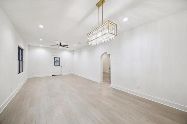 an empty room with wooden floor and ceiling fan