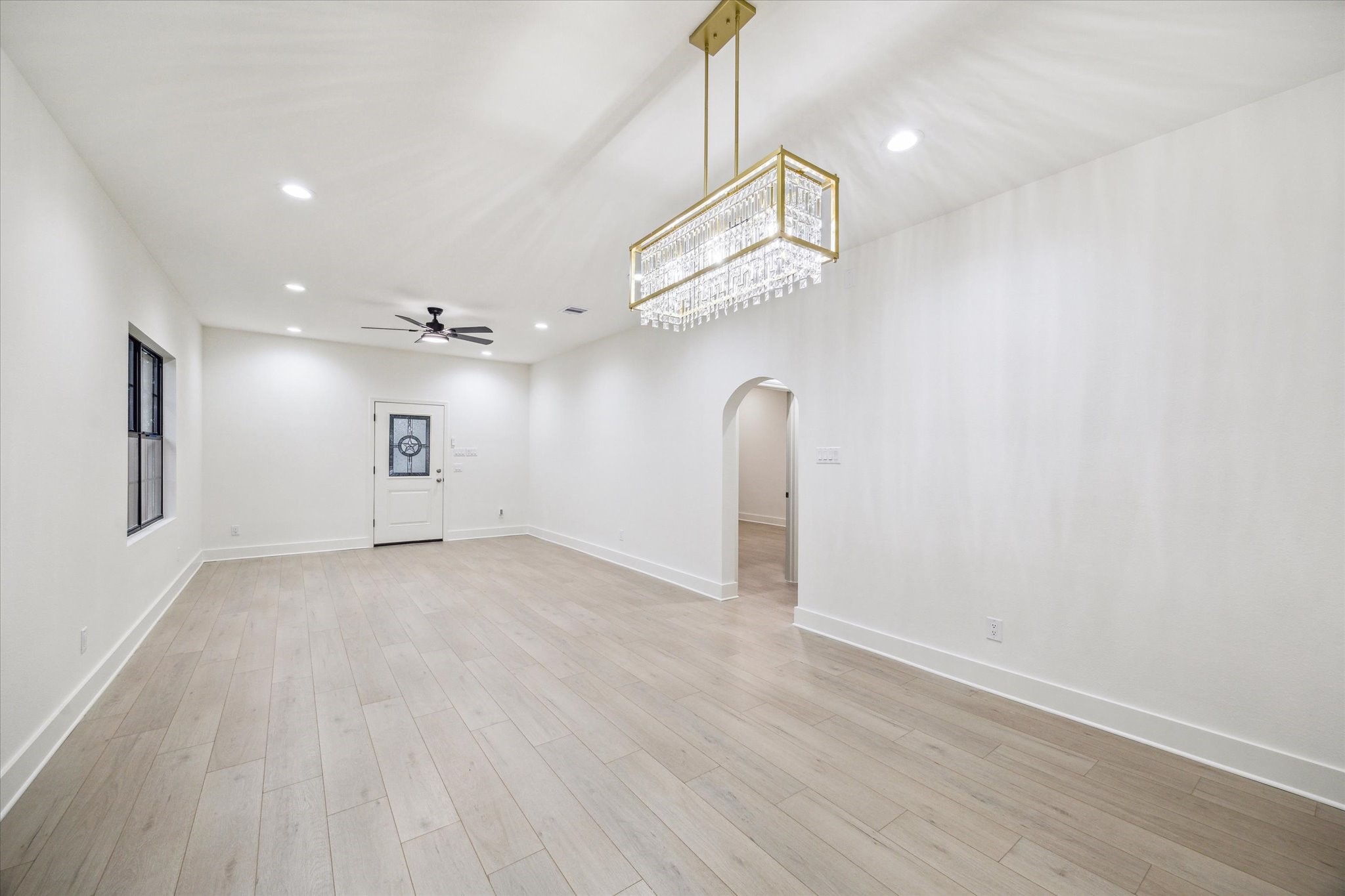 228 Lenox Street Houston, TX 77011 - Photo 4 of 16 an empty room with wooden floor and ceiling fan
