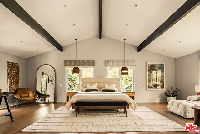 a bedroom with a bed and wooden floor