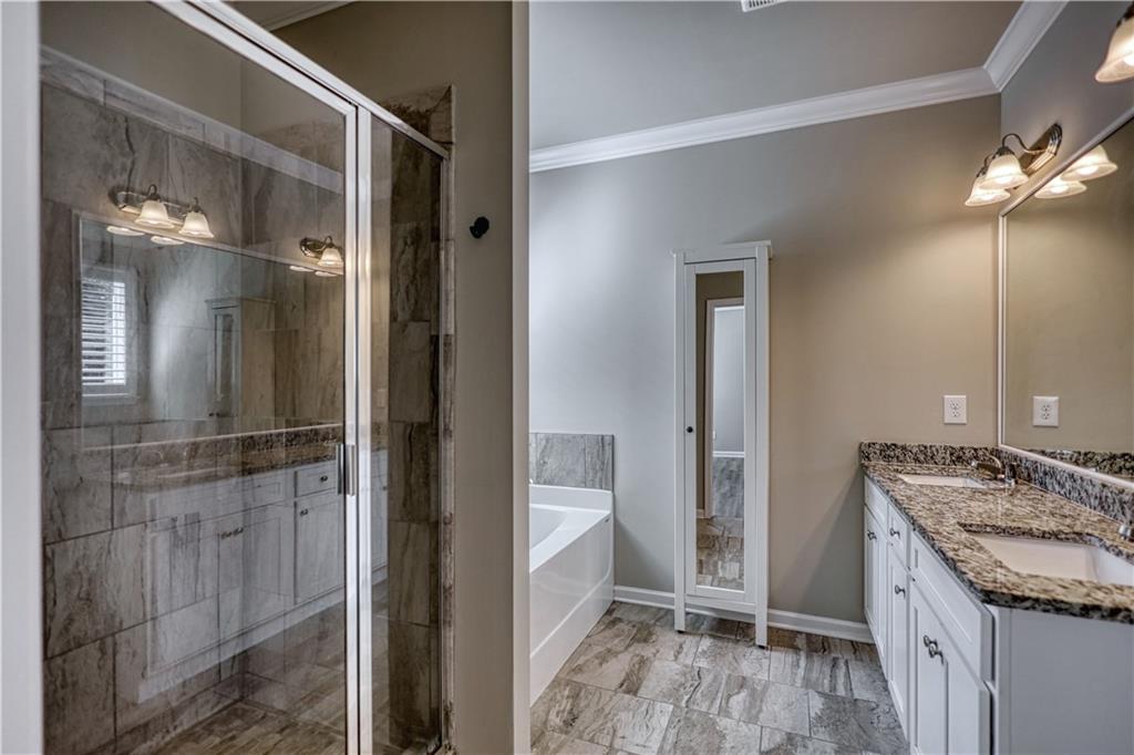 325 Tarpley Way Covington, GA 30016 - Photo 20 of 62 a bathroom with a granite countertop sink mirror and shower