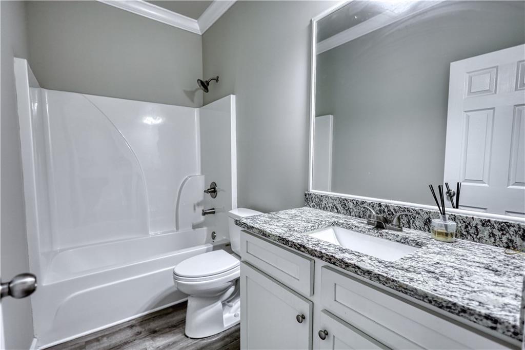 325 Tarpley Way Covington, GA 30016 - Photo 30 of 62 a bathroom with a granite countertop sink a toilet and shower