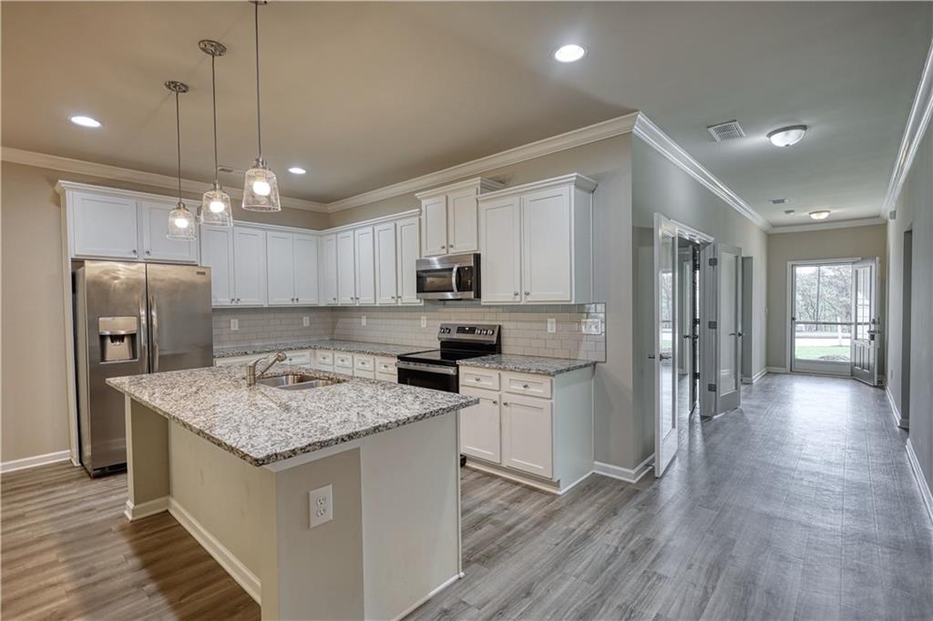 325 Tarpley Way Covington, GA 30016 - Photo 4 of 62 a kitchen with stainless steel appliances granite countertop a sink stove and refrigerator