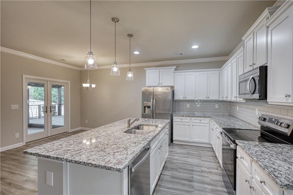 325 Tarpley Way Covington, GA 30016 - Photo 5 of 62 a kitchen with stainless steel appliances granite countertop a sink stove and refrigerator