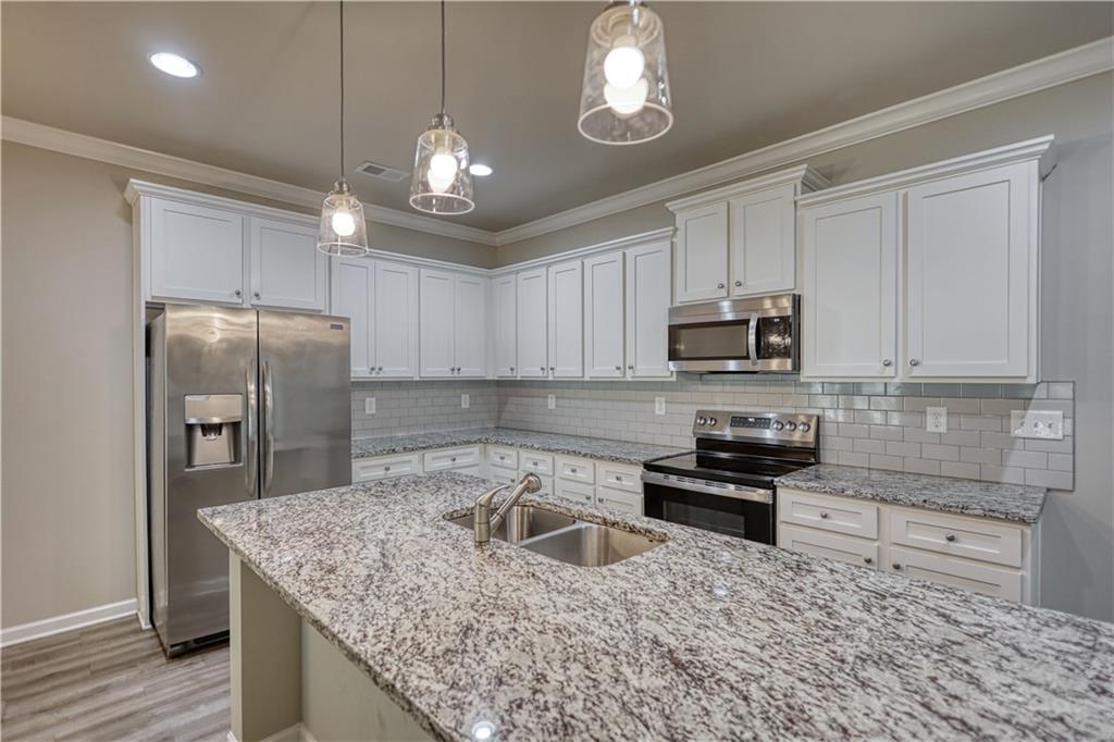 325 Tarpley Way Covington, GA 30016 - Photo 6 of 62 a kitchen with stainless steel appliances granite countertop a sink stove and refrigerator