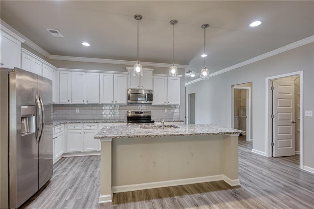 325 Tarpley Way Covington, GA 30016 - Photo 7 of 62 a kitchen with stainless steel appliances granite countertop a sink a stove and refrigerator