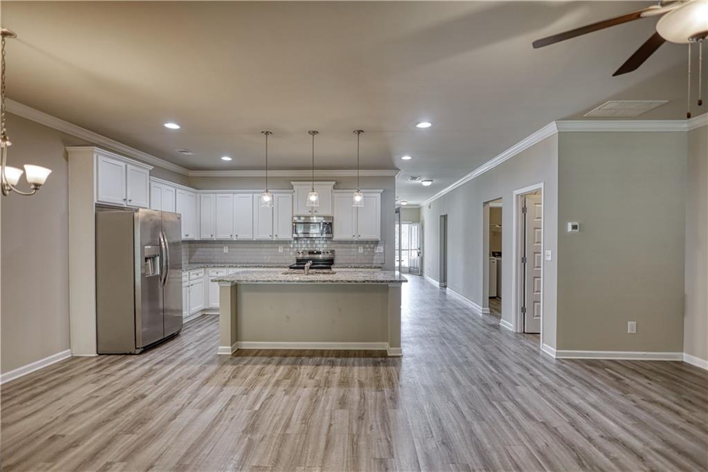 325 Tarpley Way Covington, GA 30016 - Photo 9 of 62 a kitchen with stainless steel appliances a refrigerator sink and wooden cabinets