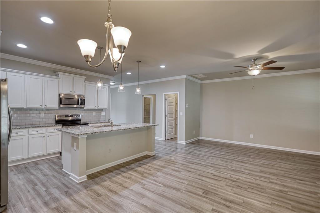 325 Tarpley Way Covington, GA 30016 - Photo 10 of 62 a kitchen with a stove cabinets and wooden floor
