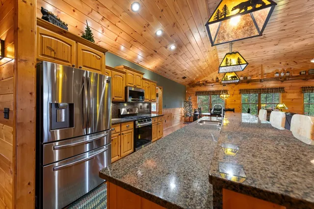 a kitchen with stainless steel appliances granite countertop a sink a stove and a refrigerator