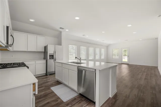 a kitchen with a sink a stove and cabinets