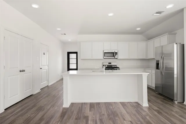 a kitchen with stainless steel appliances granite countertop a stove a sink and a refrigerator