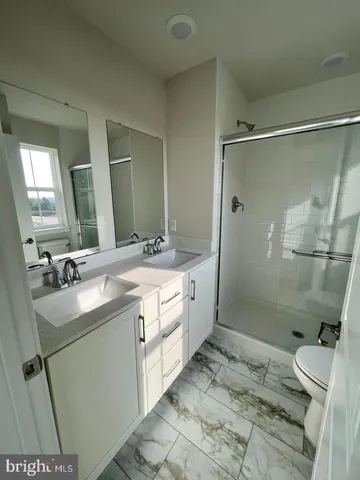 a spacious bathroom with a sink mirror vanity and toilet