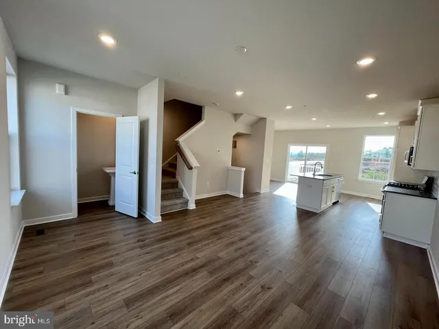 a view of an empty room and a kitchen with furniture wooden floor and a kitchen