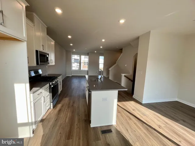 a kitchen view with wooden floor and black appliances