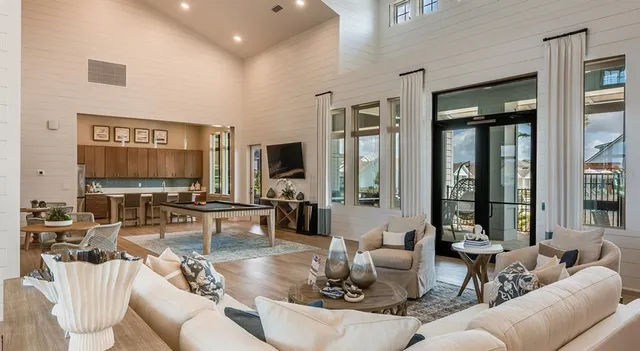 a living room with furniture flat screen tv and large window