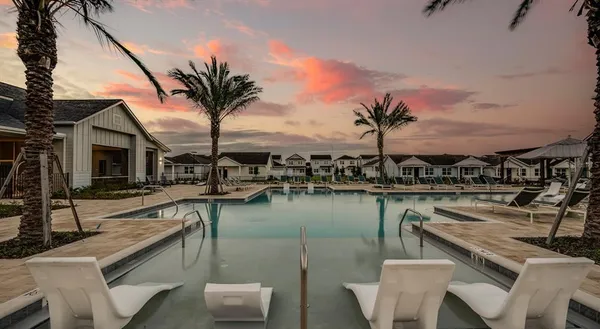 a view of a lake with couches chairs and potted plants