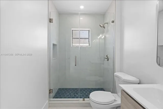 a view of a yard with a house and trees in the background