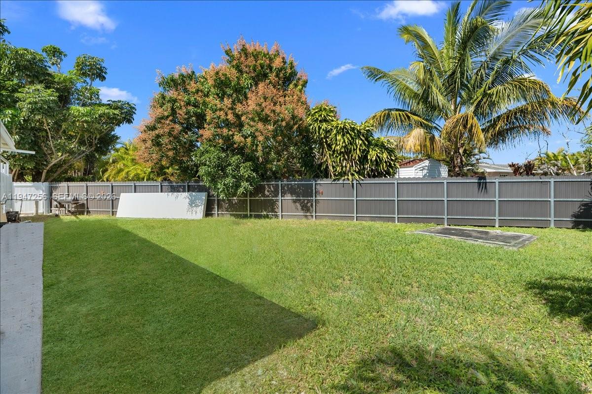 10351 Southwest 164th Street Miami, FL 33157 - Photo 18 of 19 a view of a yard with a house and trees in the background