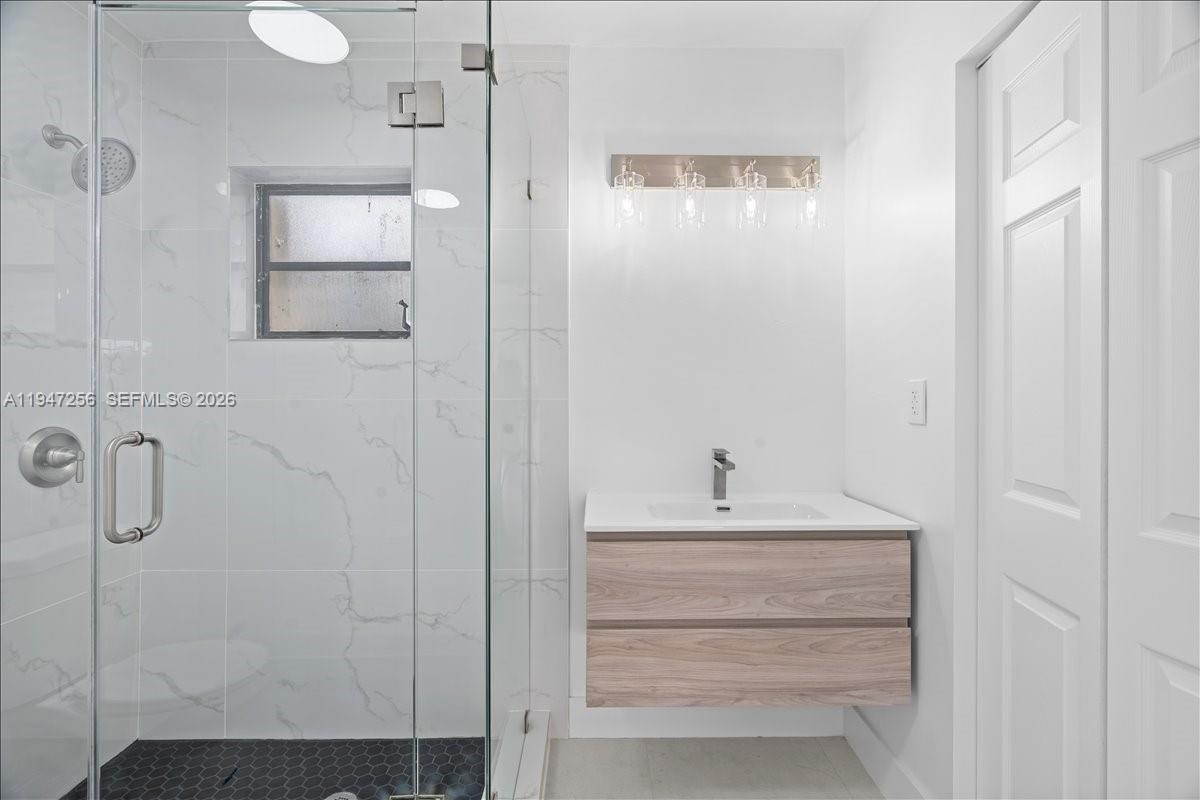 10351 Southwest 164th Street Miami, FL 33157 - Photo 10 of 19 a bathroom with a sink a mirror and shower