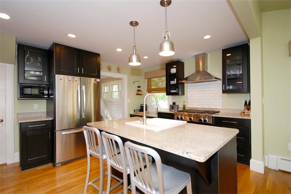 11 Westminster Road Newton, MA 02459 - Photo 5 of 26 a kitchen with granite countertop a table chairs stainless steel appliances and wooden floor