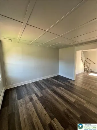 a view of empty room with wooden floor