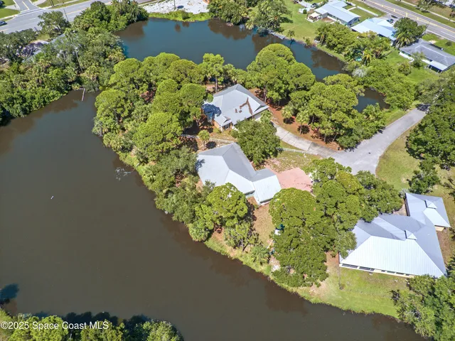 an aerial view of a house with a yard and lake view