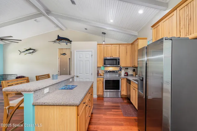 a kitchen with stainless steel appliances granite countertop a refrigerator a stove and a sink