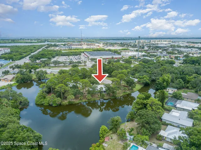 an aerial view of residential houses with outdoor space and trees