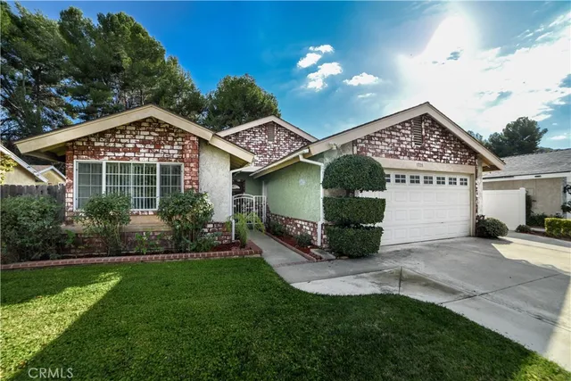 a front view of a house with a garden and plants