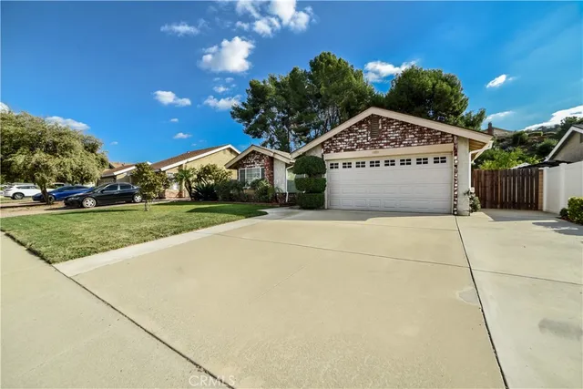 a view of a house with a yard and potted plants