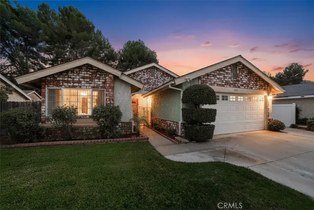 a front view of a house with a garden and yard