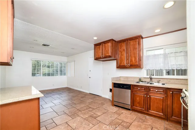 a kitchen with stainless steel appliances granite countertop a stove a sink and a microwave
