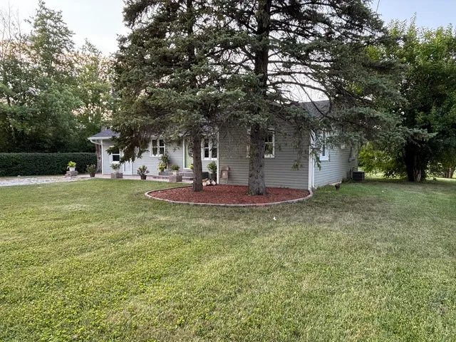 a view of a house with backyard and tree