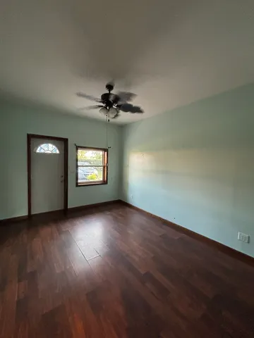 a view of empty room with wooden floor and window