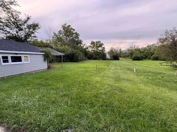 a backyard of a house with lots of green space and mountain view