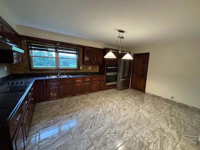 a kitchen with stainless steel appliances granite countertop a stove and a refrigerator