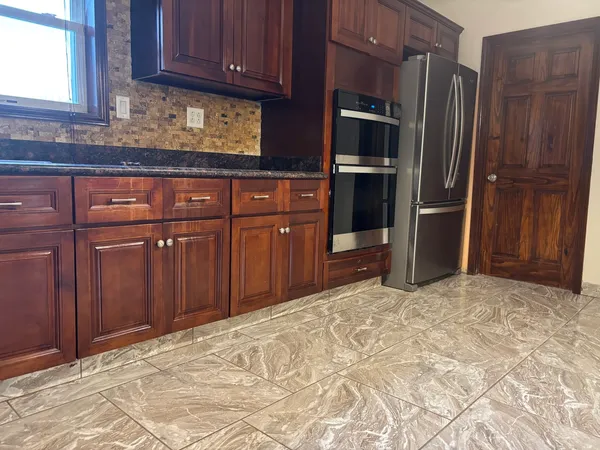 a kitchen with granite countertop wooden cabinets and stainless steel appliances