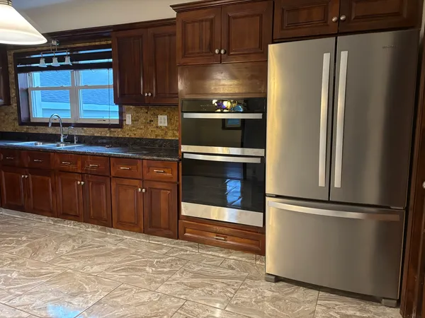 a kitchen with granite countertop stainless steel appliances and wooden cabinets